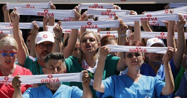 <p>Trabalhadores da saúde pública da Roménia pararam novamente no segundo dia de uma greve sectorial por tempo indeterminado. Cerca de dois terços do sector protesta contra as alterações à lei laboral que perpetuarão as desigualdades salariais e diminuirão os rendimentos dos trabalhadores. Bucareste, Roménia, 29 de Julho de 2026&nbsp;</p>