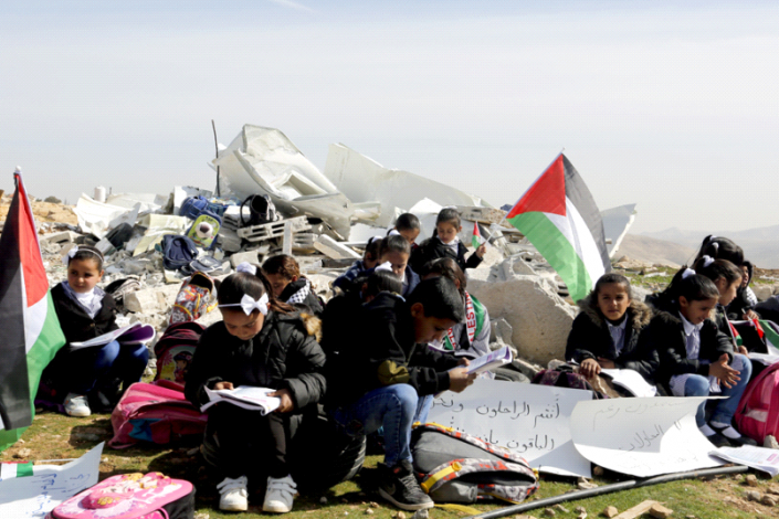 Crianças palestinianas dos 3.º e 4.º anos a estudar nos escombros das salas de aula demolidas no domingo pelos israelitas em Abu Nuwar